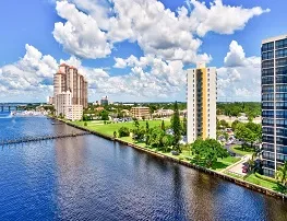 An aerial view of Fort Myers Presbyterian Apartments and surrounding buildings situated on the Caloosahatchee River.